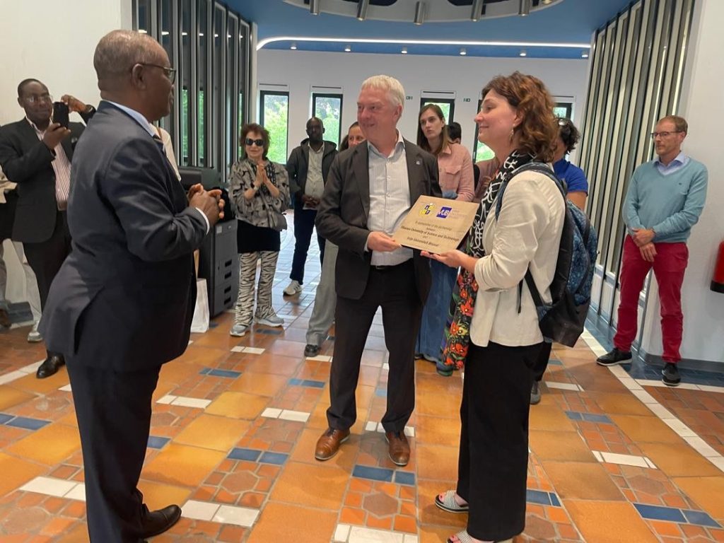 L-R: Prof. Kazooba-Tushambomwe handing over a gift to Prof. Jan Danckaert, the Rector of VUB and Prof. Gily Coene