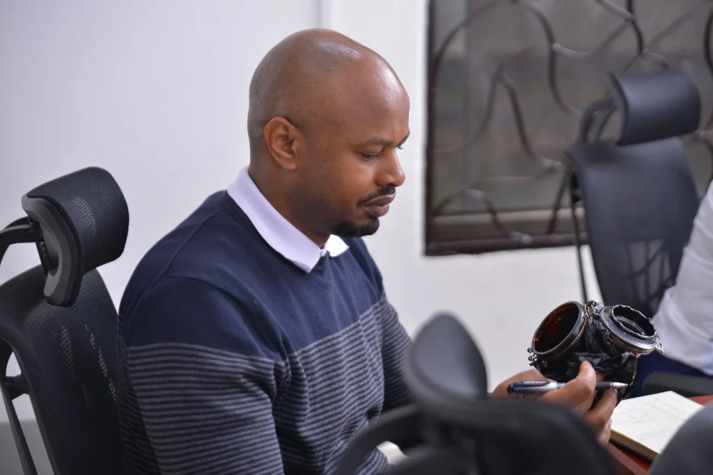 Close look: the University secretary Mr. Vincent Kwatampora taking a close look at the first oil sample