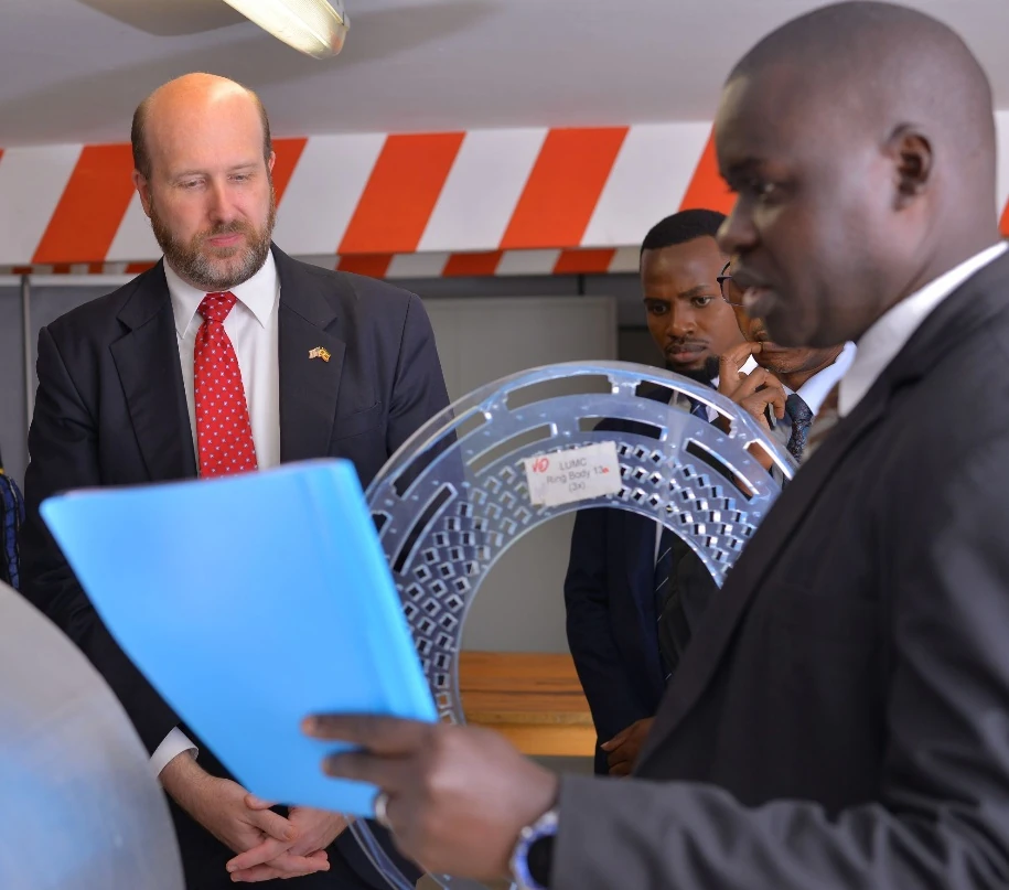 Ambassador Popp listening to Dr. Johnes Obungoloch presenting about the Magnetic Resonance Imaging (MRI) innovation to provide services at a reduced cost